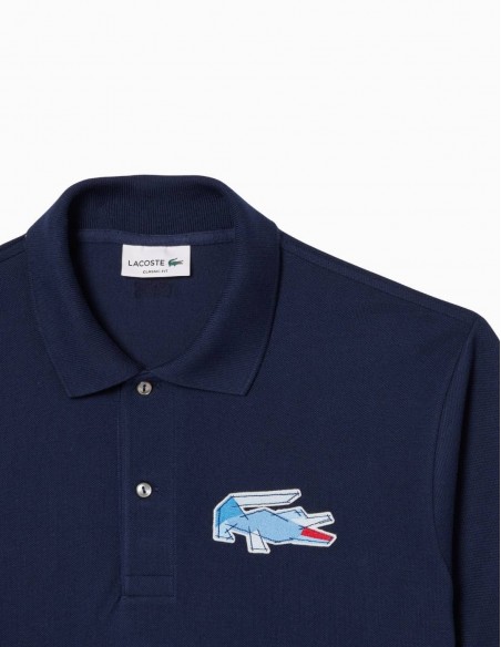POLO LACOSTE L.12.12 CON INSIGNIA CLÁSICO AZUL...